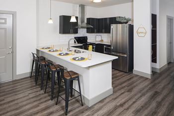 A kitchen with a large island and black appliances